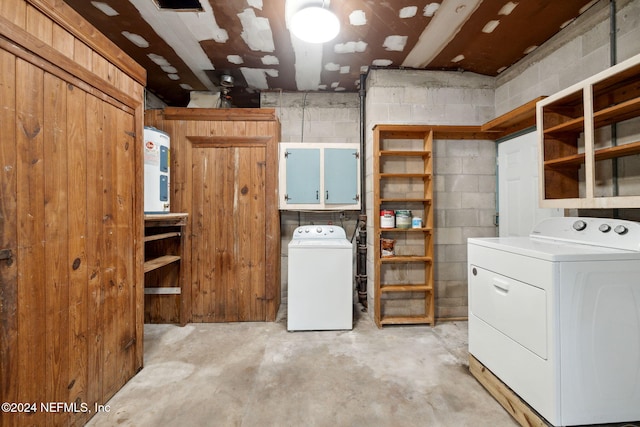 laundry room with water heater, cabinets, and washing machine and clothes dryer