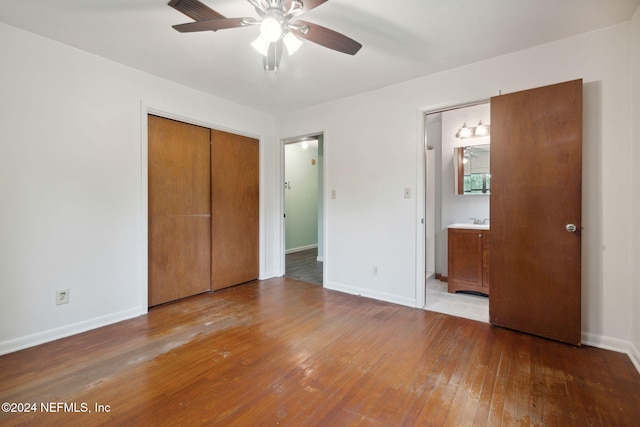 unfurnished bedroom featuring light wood-type flooring, connected bathroom, ceiling fan, and a closet