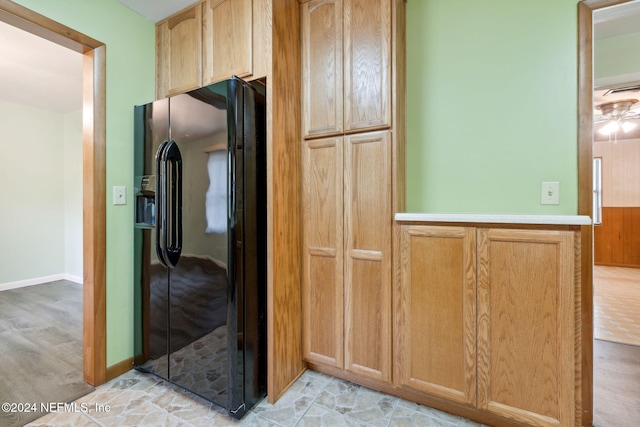 kitchen with black fridge and light brown cabinets