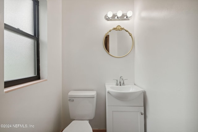 bathroom with plenty of natural light, vanity, and toilet