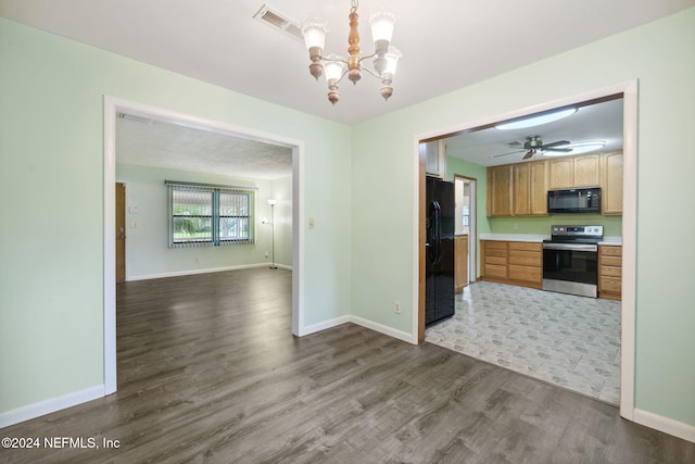 kitchen featuring black appliances, dark wood-type flooring, hanging light fixtures, and ceiling fan with notable chandelier