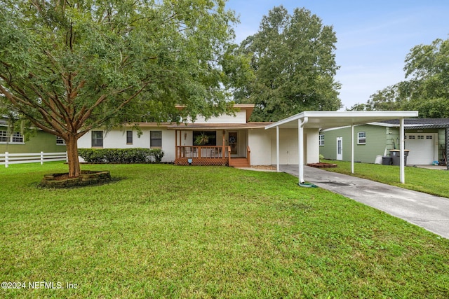 ranch-style house featuring a garage, a porch, a front lawn, and a carport