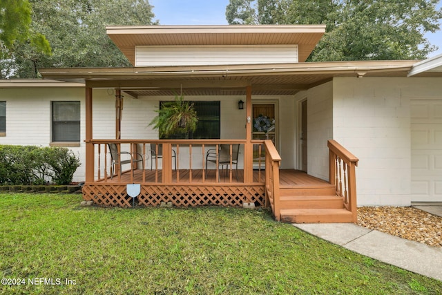 property entrance with a lawn and covered porch