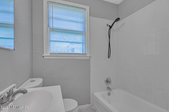 full bathroom featuring toilet, tiled shower / bath, and sink