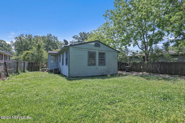 exterior space with central air condition unit and a yard