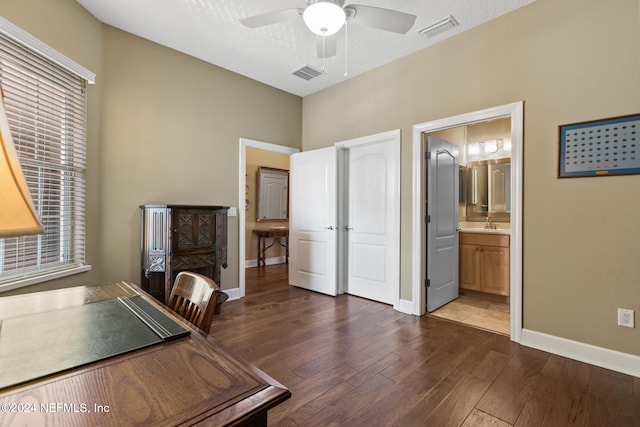 unfurnished office featuring a textured ceiling, dark hardwood / wood-style floors, and ceiling fan