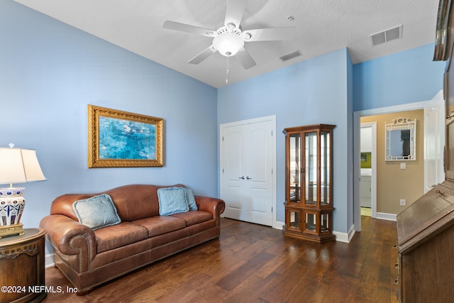 living room with ceiling fan, dark hardwood / wood-style floors, and a textured ceiling