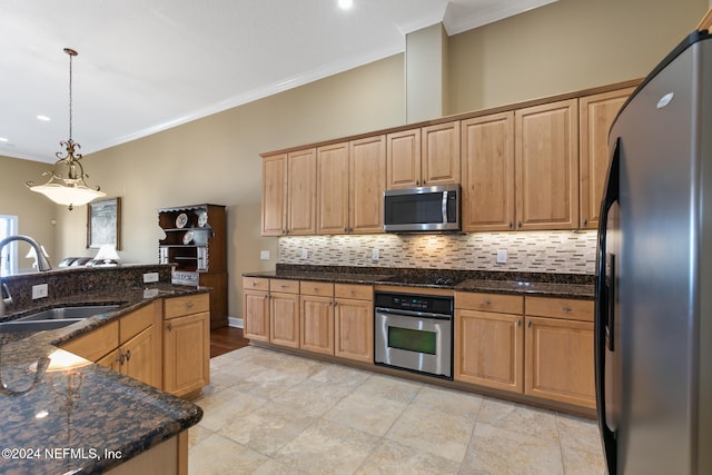 kitchen featuring sink, crown molding, appliances with stainless steel finishes, decorative light fixtures, and dark stone countertops