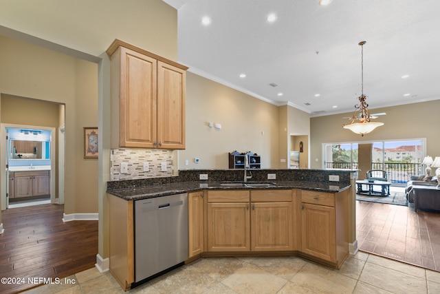 kitchen with dark stone counters, pendant lighting, sink, light hardwood / wood-style floors, and stainless steel dishwasher