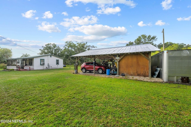 view of yard featuring a storage shed, a porch, and a carport