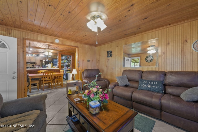 living room with wooden ceiling, ceiling fan, wooden walls, and light tile patterned floors