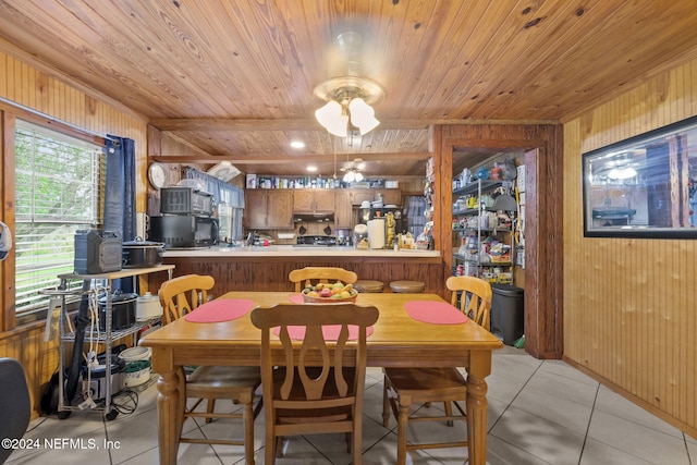 tiled dining area featuring wood walls and wood ceiling