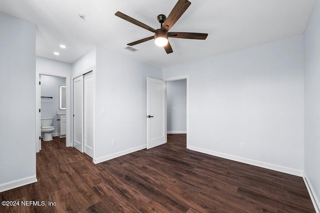 unfurnished bedroom with ensuite bath, ceiling fan, a closet, and dark wood-type flooring