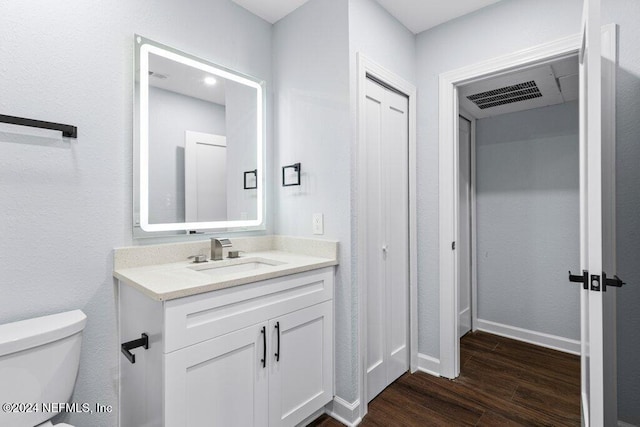 bathroom featuring wood-type flooring, vanity, and toilet