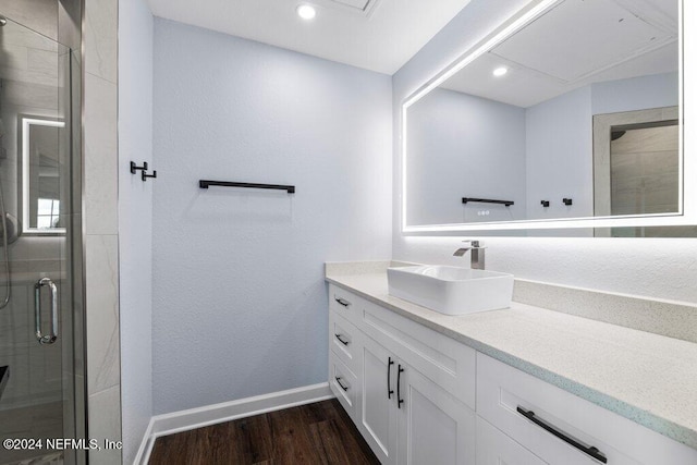 bathroom with hardwood / wood-style flooring, vanity, and walk in shower