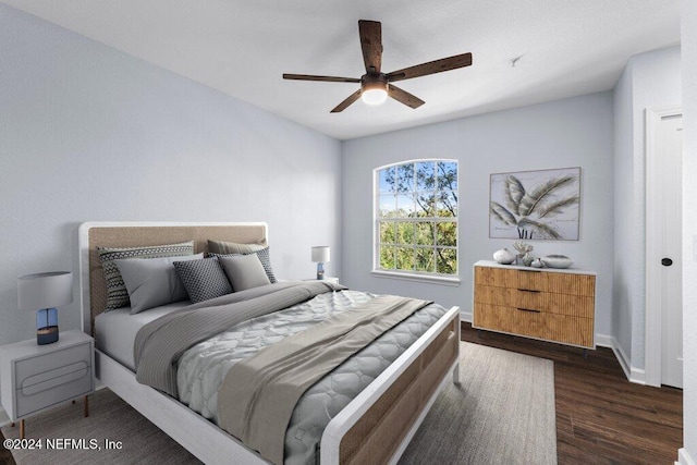 bedroom with dark hardwood / wood-style floors and ceiling fan