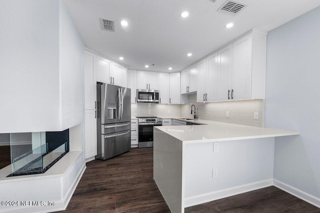 kitchen featuring white cabinetry, stainless steel appliances, and dark wood-type flooring