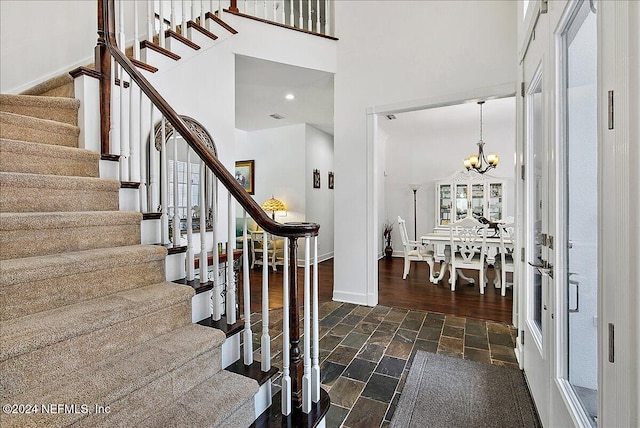 entrance foyer featuring dark hardwood / wood-style floors, a high ceiling, and an inviting chandelier