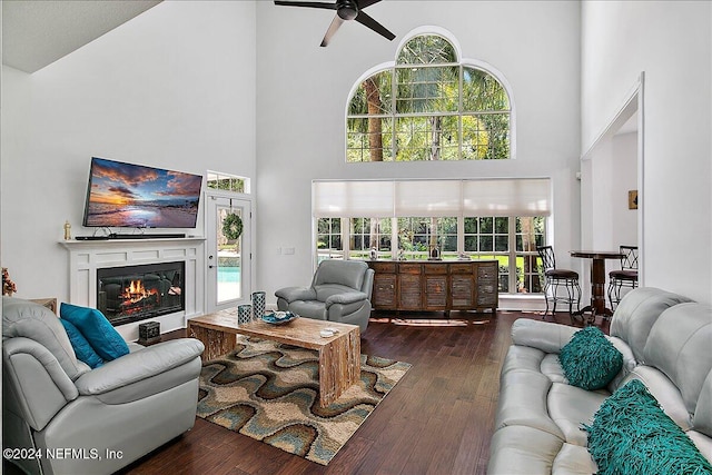 living room with high vaulted ceiling, dark wood-type flooring, and a healthy amount of sunlight