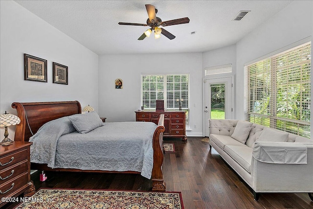 bedroom featuring access to exterior, dark wood-type flooring, multiple windows, and ceiling fan