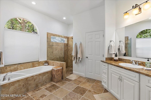 bathroom with vanity and shower with separate bathtub