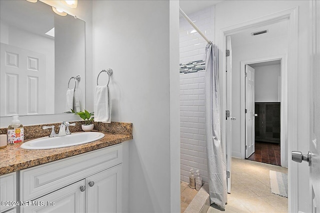 bathroom with tile patterned flooring, curtained shower, and vanity