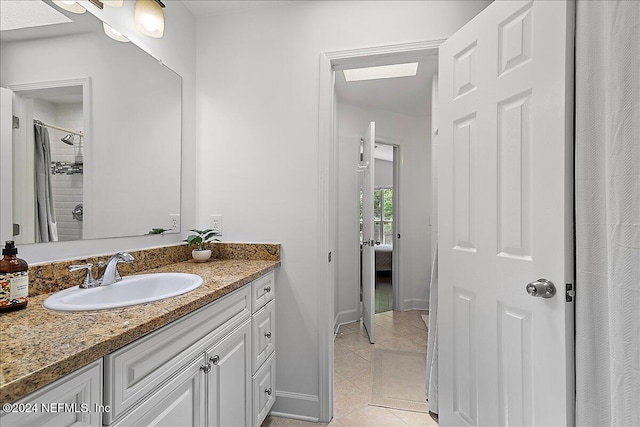 bathroom featuring a skylight, tile patterned floors, and vanity