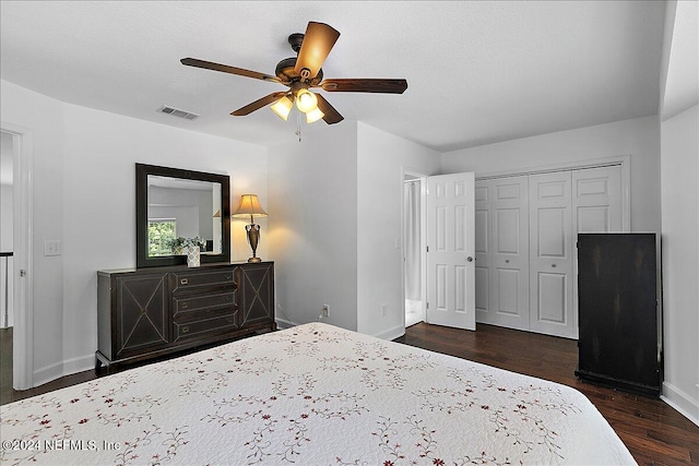 bedroom with dark wood-type flooring, ceiling fan, and a closet