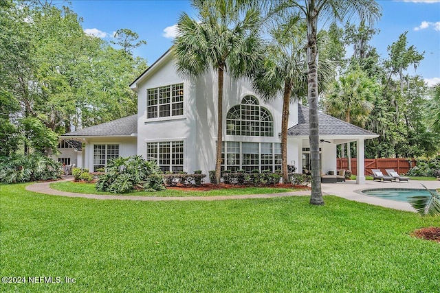 rear view of house featuring a patio and a yard