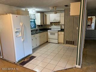 kitchen featuring white appliances, white cabinetry, and light tile patterned floors