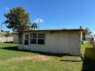 rear view of property with a lawn