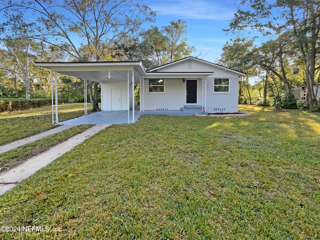 view of front of home with a carport and a front lawn