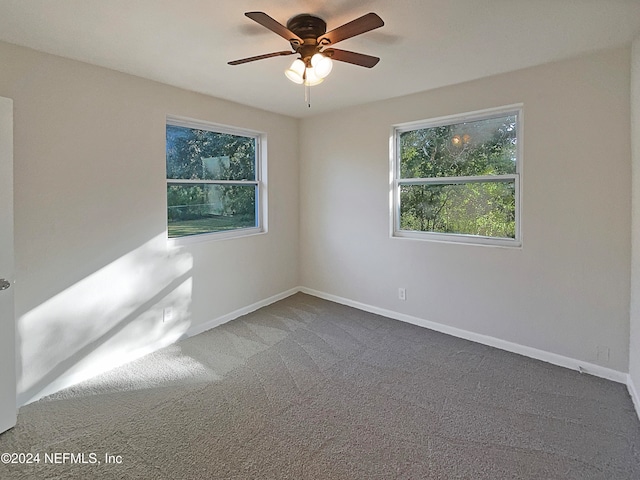 empty room featuring ceiling fan and carpet