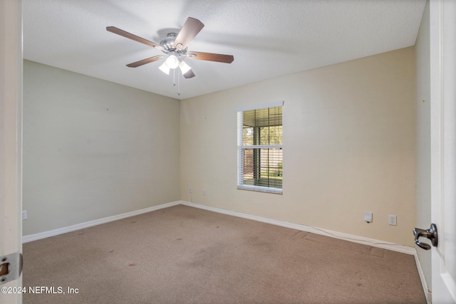 carpeted spare room with a textured ceiling and ceiling fan