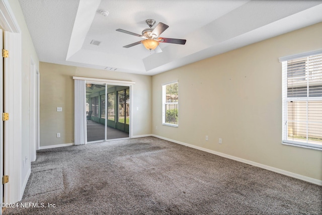 spare room featuring ceiling fan, a textured ceiling, carpet floors, and a tray ceiling