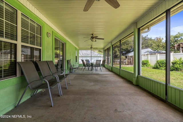 unfurnished sunroom with ceiling fan