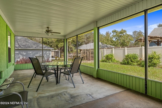 unfurnished sunroom featuring ceiling fan and plenty of natural light