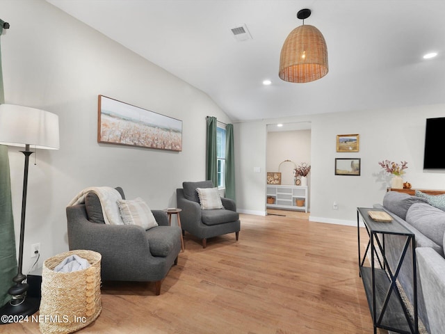 living area with vaulted ceiling and light hardwood / wood-style flooring