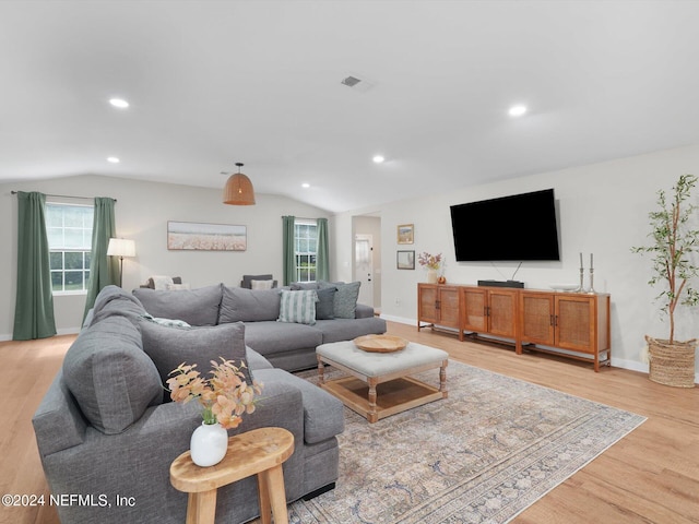 living room with light wood-type flooring and lofted ceiling