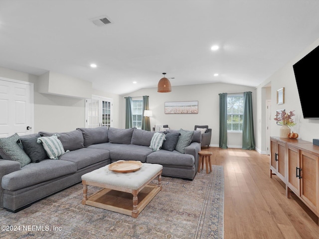 living room featuring light wood-type flooring and vaulted ceiling