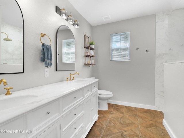 bathroom featuring parquet floors, vanity, and toilet