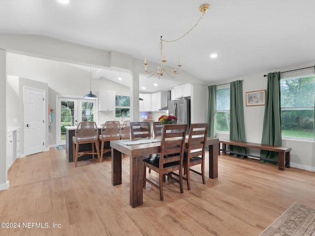 dining space featuring a wealth of natural light, lofted ceiling, light hardwood / wood-style floors, and an inviting chandelier