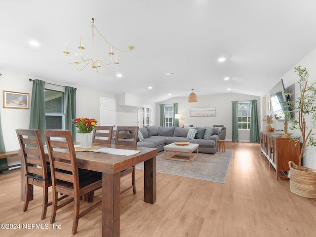 dining room featuring light hardwood / wood-style flooring, a chandelier, and vaulted ceiling