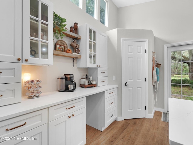 bar with white cabinetry and light wood-type flooring