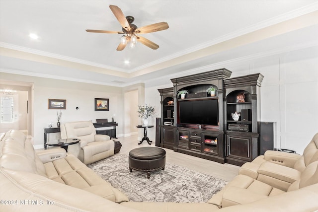 living room featuring hardwood / wood-style flooring, ceiling fan with notable chandelier, and ornamental molding