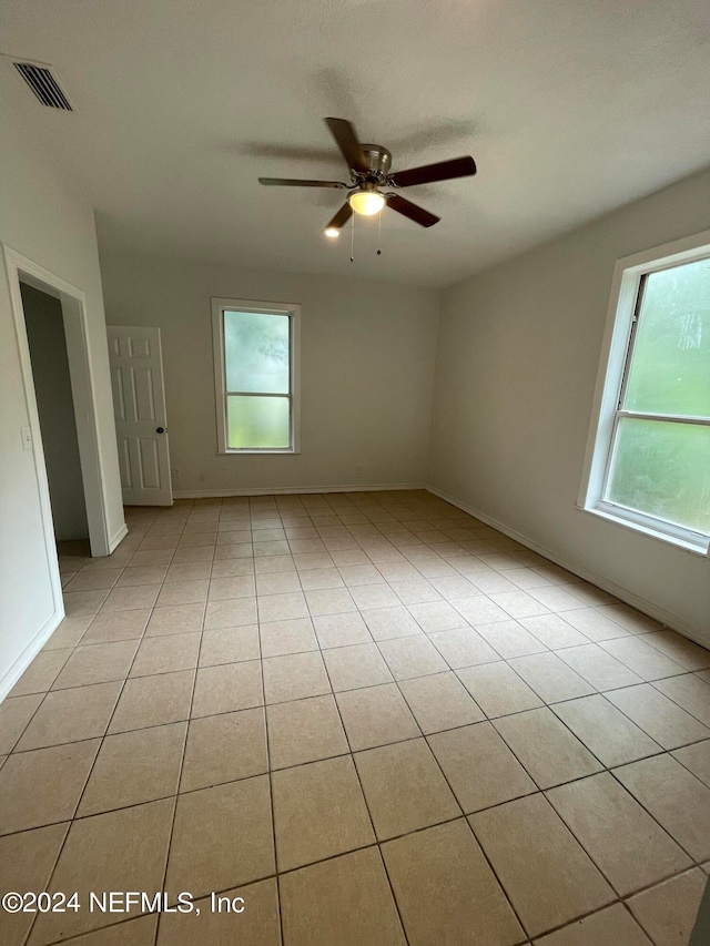 unfurnished room with light tile patterned floors and ceiling fan