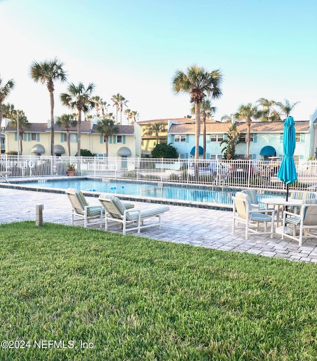 view of swimming pool with a patio and a yard