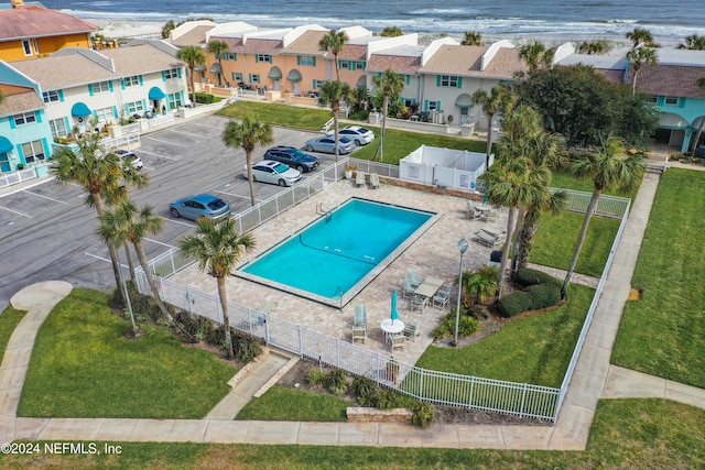 view of pool featuring a lawn, a patio, and a water view