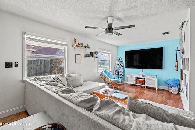 living room featuring a textured ceiling, hardwood / wood-style flooring, and ceiling fan