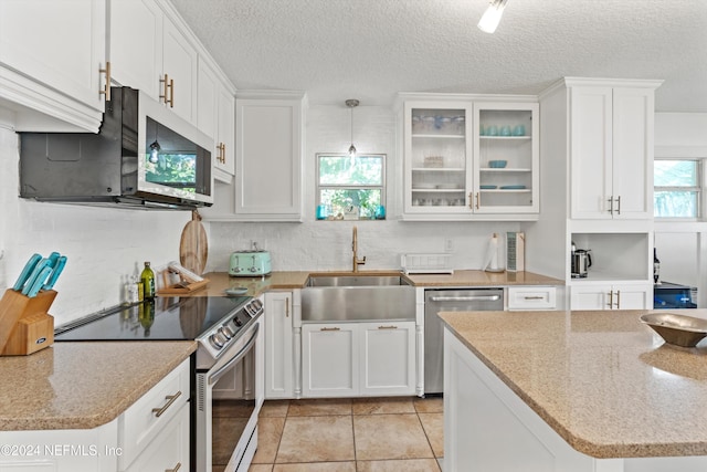 kitchen with pendant lighting, plenty of natural light, white cabinetry, and appliances with stainless steel finishes